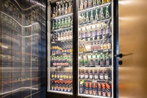 a refrigerator filled with lots of bottles of alcohol at NOA Hotel SHENZHEN LUOHU in Shenzhen