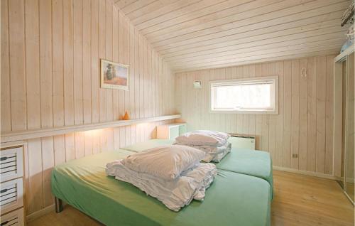a bedroom with two beds with pillows and a window at 4 Bedroom Lovely Home In Nex in Snogebæk