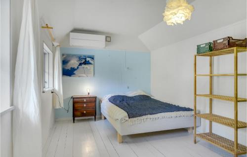 een slaapkamer met een bed en een houten plank bij Beach Front Home In Strby With Kitchen in Strøby