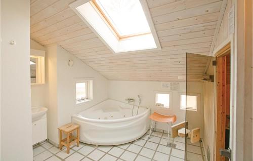 a bathroom with a large tub and a skylight at 4 Bedroom Lovely Home In Nex in Snogebæk