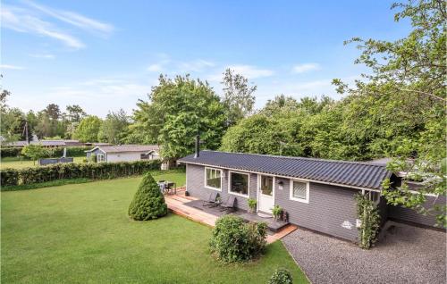 a tiny house with a deck in a yard at Two-Bedroom Holiday Home In Jagerspris in Jægerspris