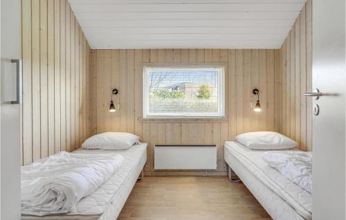 two beds in a room with a window at Awesome Home In Otterup With Sauna in Hasmark