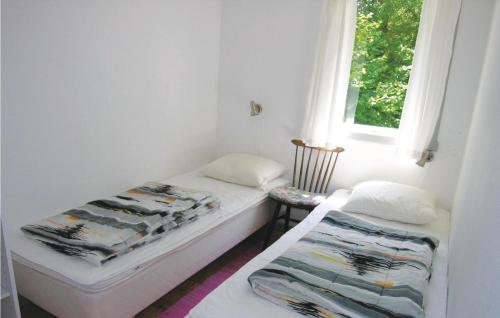 Vester SømarkenにあるFyrrelsのベッド2台と窓が備わる小さな客室です。