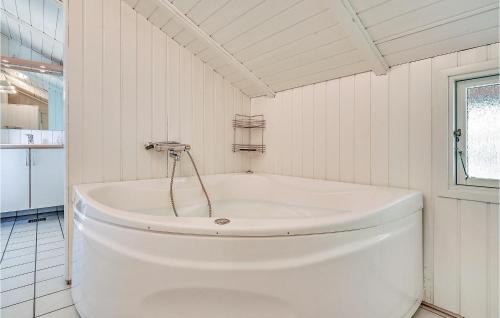 バイアス・スタンにあるBeautiful Home In Vejers Strand With 3 Bedrooms, Sauna And Wifiの白いバスルーム(白いバスタブ、窓付)