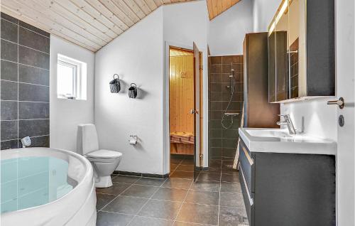 a bathroom with a tub and a toilet and a sink at Gorgeous Home In Bogense With Wifi in Bogense