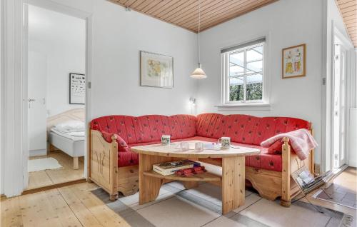 ein Wohnzimmer mit einem roten Sofa und einem Tisch in der Unterkunft Joe in Rønne