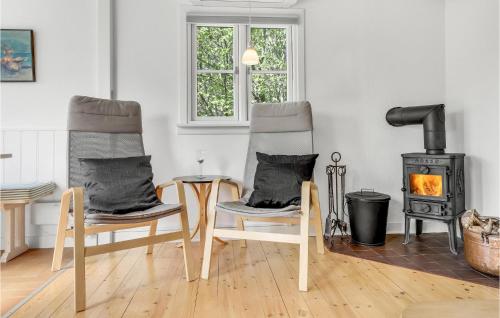two chairs and a table in a living room with a stove at Joe in Rønne