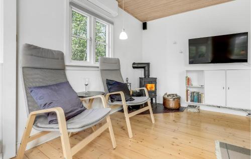 a living room with two chairs and a table and a tv at Joe in Rønne