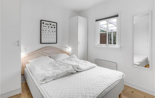 a white bedroom with a white bed and a window at Joe in Rønne