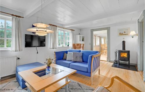 a living room with a blue couch and a table at Holiday Home Sønderbyvej Rømø Ii in Rømø Kirkeby