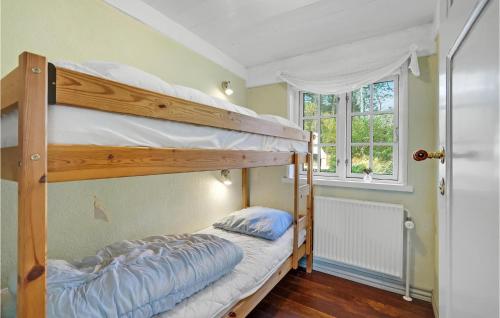 a bedroom with two bunk beds and a window at Holiday Home Sønderbyvej Rømø Ii in Rømø Kirkeby