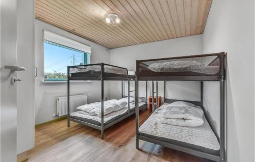 two bunk beds in a room with a window at Lovely Home In Lgumkloster With House A Panoramic View in Agerskov