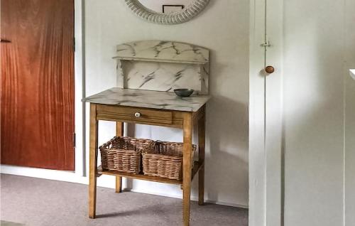 a small table with a basket and a mirror at Lovely Home In Millinge With Kitchen in Millinge