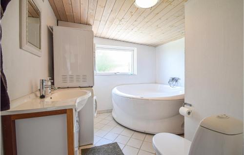 a bathroom with a tub and a toilet and a sink at Beautiful Home In Bjert With Wifi in Sønder Bjert
