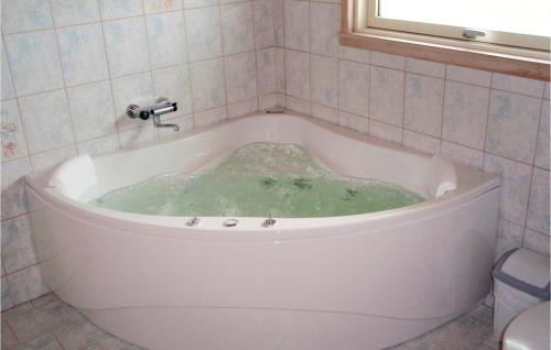 La salle de bains est pourvue d'une baignoire remplie de liquide vert. dans l'établissement Stunning Home In Humble With Sauna, à Humble