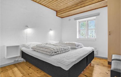 TvedhuseにあるAmazing Home In Glesborg With 4 Bedrooms, Sauna And Wifiの白いベッドルーム(ベッド1台、テレビ付)
