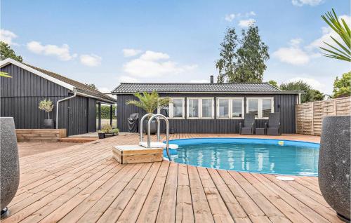 a swimming pool on a wooden deck next to a house at Stunning Home In Holbæk in Holbæk