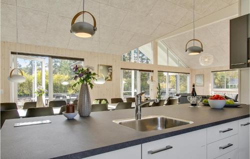 a kitchen with a sink and some chairs and windows at Seven-Bedroom Holiday Home In Frederiksvark in Frederiksværk
