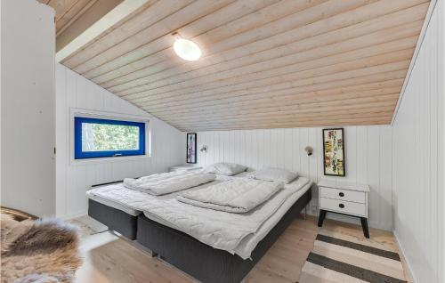 1 dormitorio con 1 cama grande y techo de madera en Nice Home In Juelsminde With Sauna en Sønderby