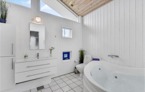 baño blanco con bañera y aseo en Nice Home In Juelsminde With Sauna en Sønderby