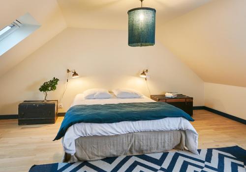 um quarto com uma cama grande num sótão em La vigie d'Héloïse, appartement de l'Aod em Lampaul