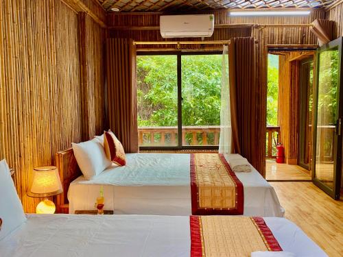 una camera con due letti e una grande finestra di Bamboo Hill Villa a Ninh Binh