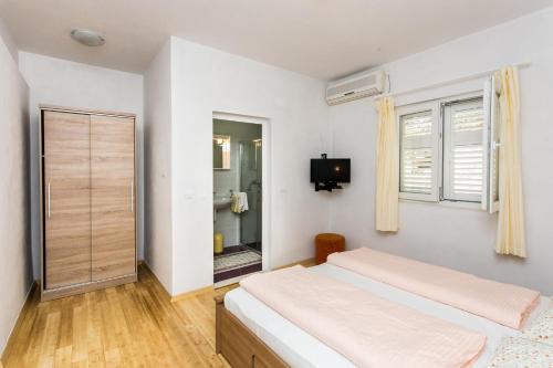 a bedroom with a bed and a television in it at Guest House Oreb in Koločep