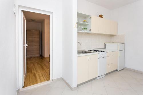 a white kitchen with white cabinets and a sink at Guest House Oreb in Koločep