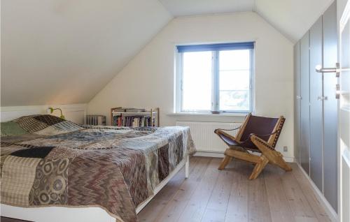 a bedroom with a bed and a chair and a window at 3 Bedroom Gorgeous Home In Hasle in Hasle