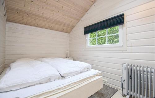 a bed in a white room with a window at Holiday Home Svinget Rønde in Rønde