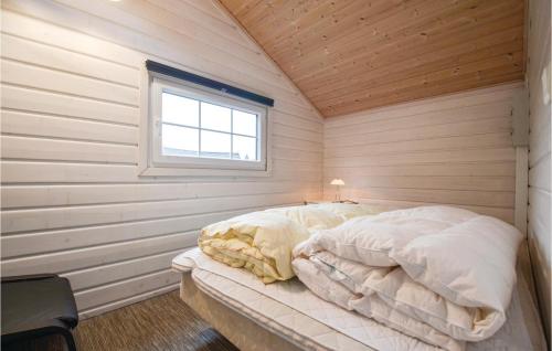 Stunning Home In Rnde With Kitchen في Rønde: سرير في غرفة خشبية مع نافذة