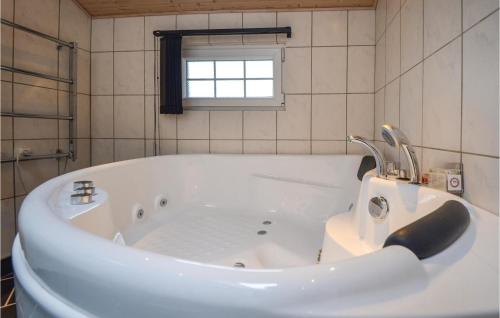 a white bath tub in a bathroom with a window at Holiday Home Svinget Rønde in Rønde
