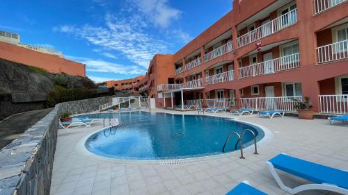 a swimming pool in front of a building at Besonderes Apartment mit einzigartigem Meerblick in Costa Calma