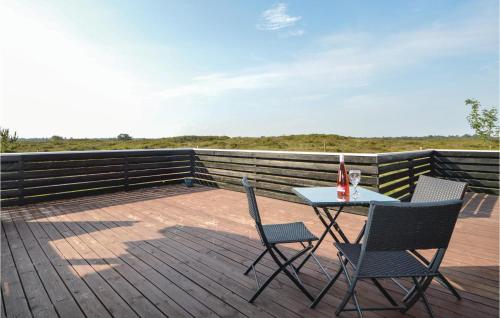 a patio with a table and chairs on a deck at Amazing Home In Rømø With Sauna in Lakolk