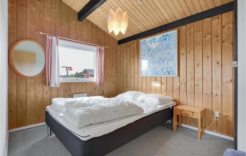 1 dormitorio con 1 cama en una pared de madera en Hedebo, en Fanø