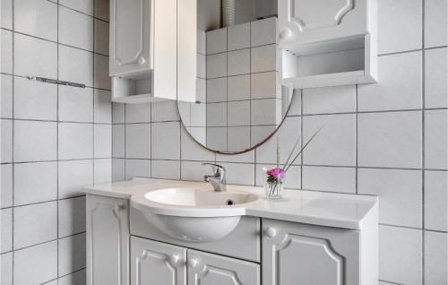 a white bathroom with a sink and a mirror at Hedebo in Fanø