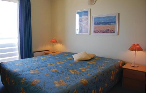 ルーケベングにあるNice Apartment In Rudkbing With 3 Bedrooms And Wifiのベッドルーム1室(青い掛け布団、ランプ2つ付)