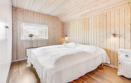 a bedroom with a white bed and a window at Nice Home In Idestrup With 4 Bedrooms, Sauna And Wifi in Marielyst