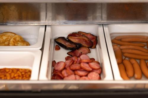 a refrigerator filled with different types of food at Hotel Belcredi in Brno