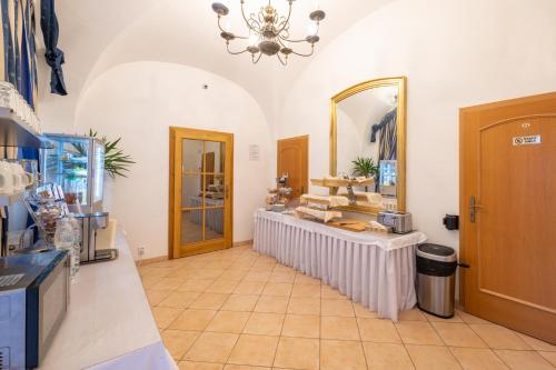 a large room with a counter and a mirror at Hotel Belcredi in Brno