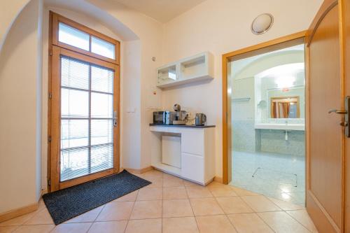 a bathroom with a shower and a door to a kitchen at Hotel Belcredi in Brno