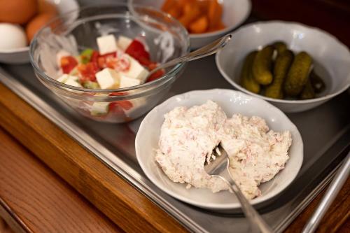a tray with plates of food and bowls of vegetables at Hotel Belcredi in Brno