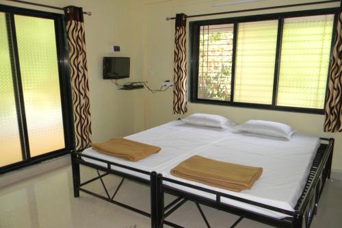 uma cama num quarto com duas toalhas em Suma beach resort em Dapoli