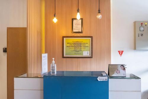 a reception desk with a bottle of water on top of it at TwoSpaces Living at Kencana Residence in Gunungsan