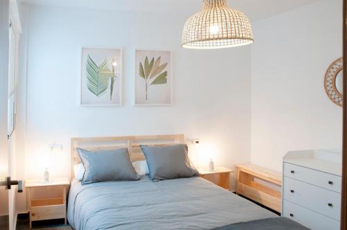 um quarto com uma cama e uma luz pendente em Felipe Antón Suites em Mutxamel