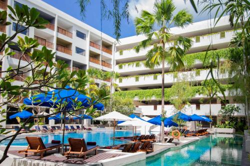 an image of a hotel pool with chairs and umbrellas at Deevana Plaza Phuket - SHA Extra Plus in Patong Beach