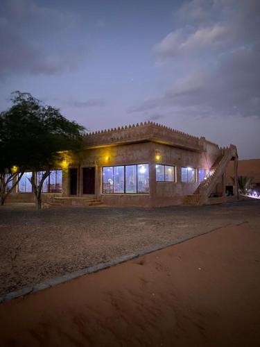 a building with a lot of windows in the night at Safari Desert Camp in Shāhiq