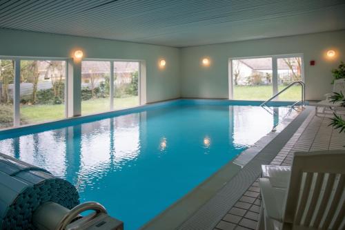 a large swimming pool with blue water in a house at Ferienwohnung Toskana mit Schwimmbad und Sauna in Bad Bergzabern