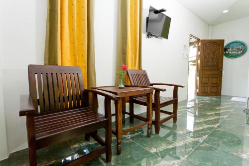two chairs and a table in a room with a television at The Mouth Resort - SHA Extra Plus in Khao Lak