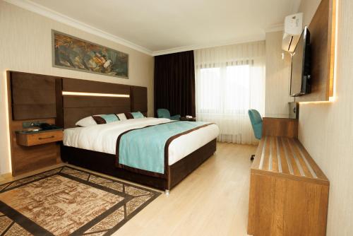 a hotel room with a bed and a television at Anemon Uşak Hotel in Uşak